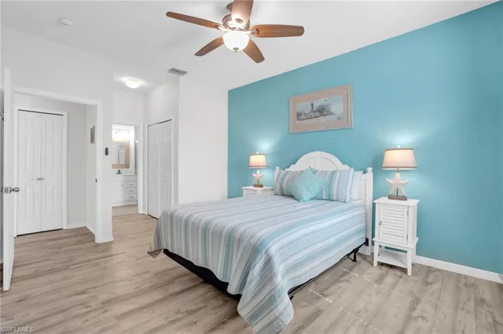 Bedroom featuring connected bathroom, light hardwood / wood-style floors, and ceiling fan