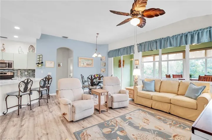 Living room with ceiling fan and light hardwood / wood-style floors