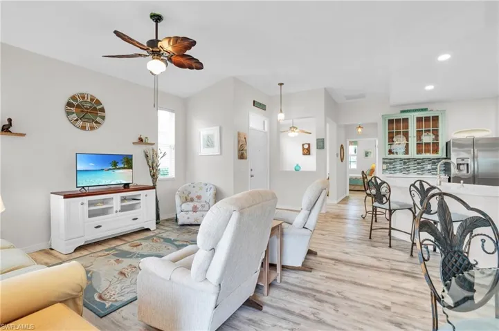 Living room with light hardwood / wood-style floors and ceiling fan
