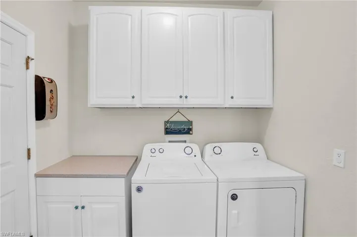 Laundry area with cabinets and washer and clothes dryer