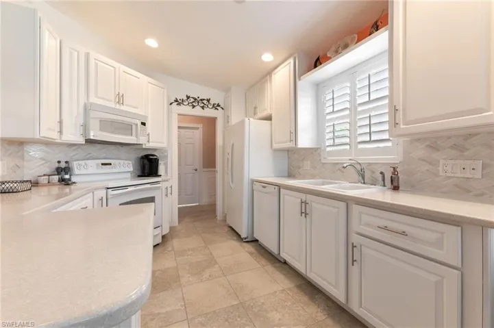 15366 Upwind Dr Bonita Springs FL 34135 - Refaced cabinets with clean neutral backsplash and updated hardware.