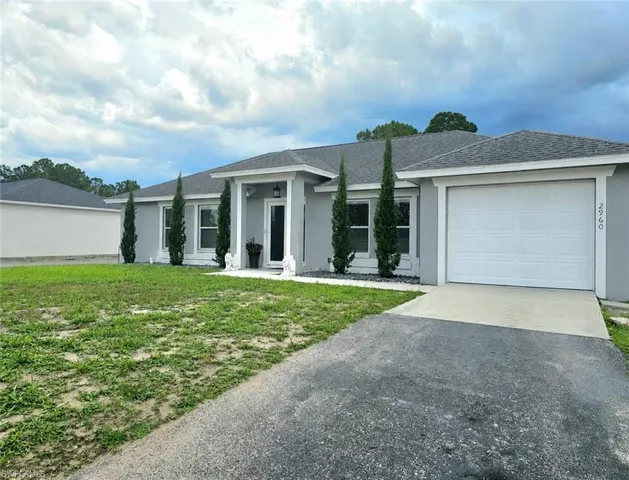 Contemporary single-story residence with a light gray stucco exterior and a dark shingle roof