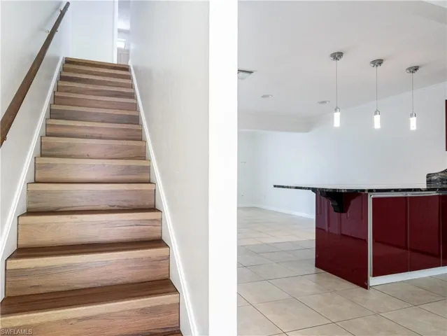 Staircase featuring crown molding and light tile floors