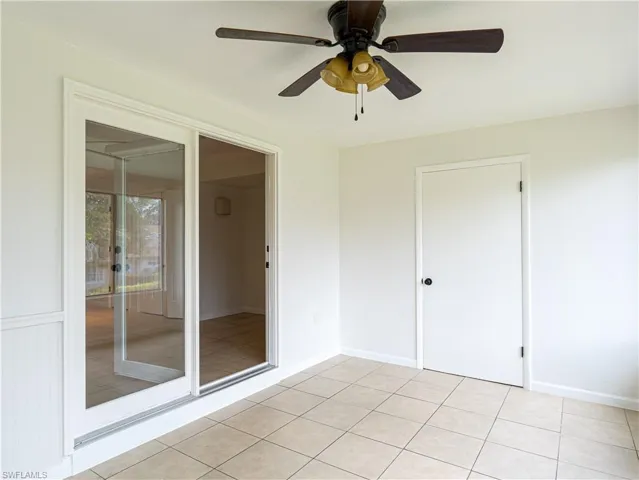Tiled empty room featuring ceiling fan
