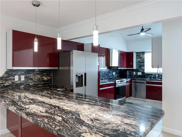 Kitchen featuring ceiling fan, tasteful backsplash, stainless steel appliances, light tile flooring, and pendant lighting