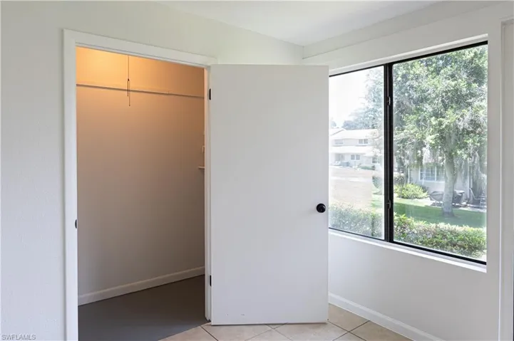 Unfurnished bedroom with a closet and light tile floors