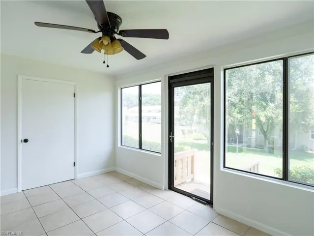 Tiled spare room featuring ceiling fan