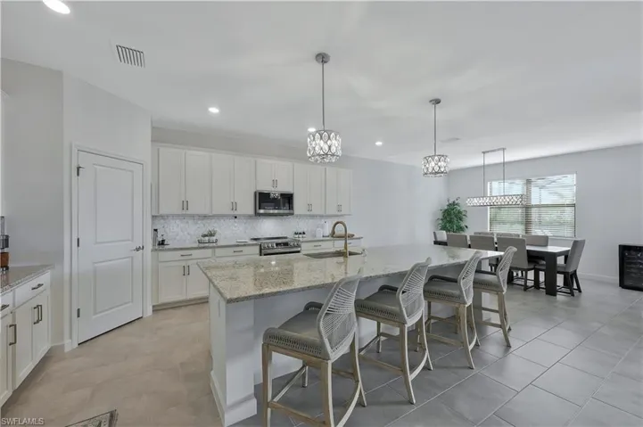 Kitchen featuring stainless steel appliances, a chandelier, backsplash, a sink, and visible vents