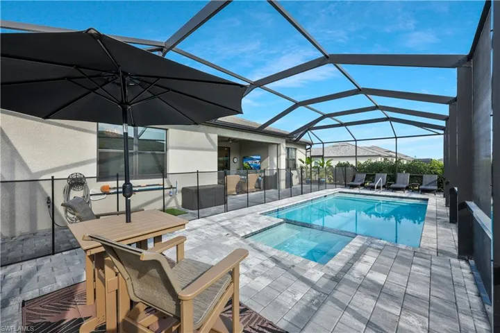 View of swimming pool featuring a pool with connected hot tub, a lanai, and a patio