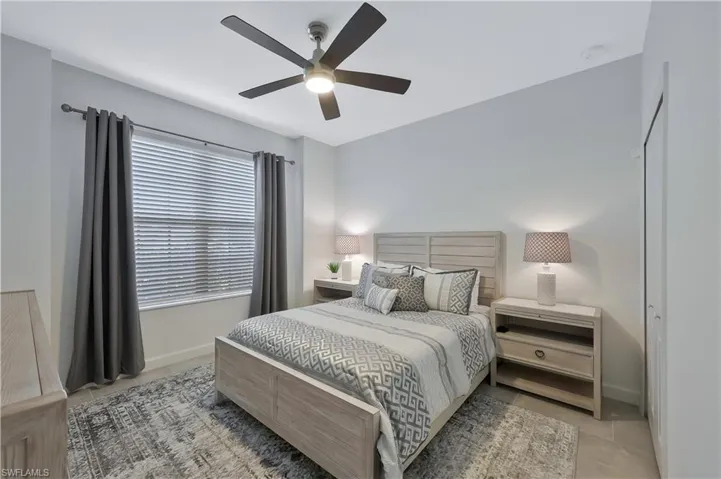 Bedroom with baseboards, ceiling fan, and light tile patterned floors