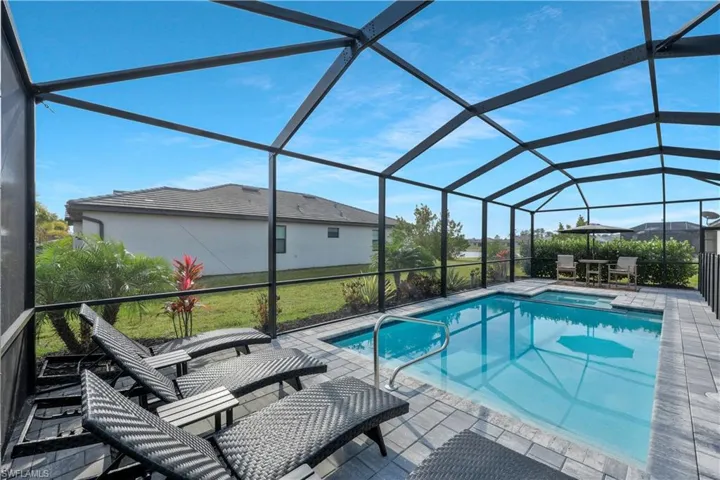 View of pool featuring a pool with connected hot tub, a lanai, and a patio