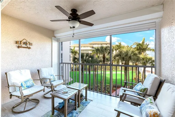 Sunroom / solarium featuring a balcony, a ceiling fan, and outdoor seating