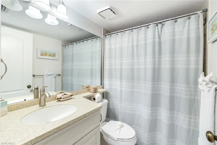Bathroom with vanity and curtained shower
