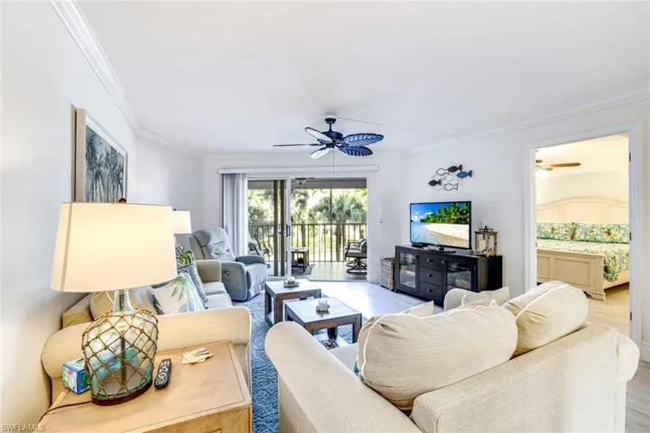 Living room featuring a ceiling fan, wood finished floors, and ornamental molding