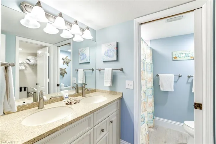 Full bath with double vanity and curtained shower