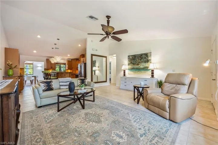 Living area opens into expansive Kitchen. Doorway on right leads to primary bedroom and garage access.