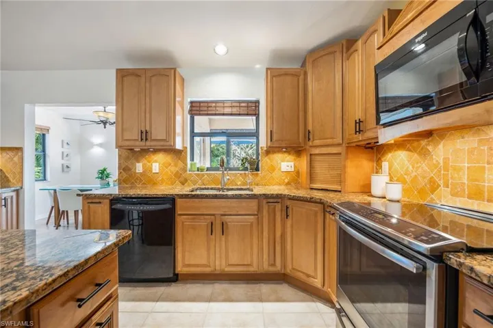42 inch cabinets, tiled backsplash, stainless steel & black appliances.