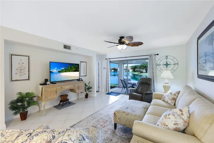 Living room with light tile patterned floors and ceiling fan
