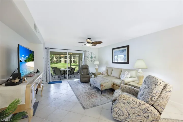 Living room featuring ceiling fan and light tile patterned floors