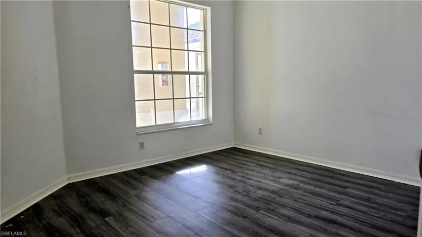 Empty room with dark wood-type flooring