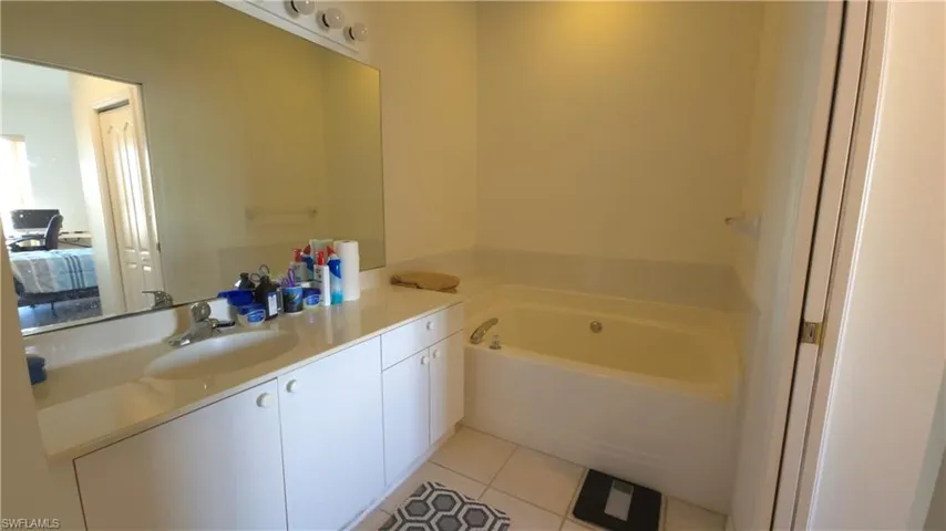 Bathroom with tile patterned flooring, a bathtub, and vanity