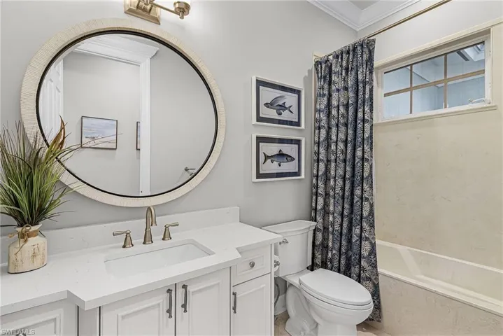 Full bath with vanity, shower / tub combo, and ornamental molding