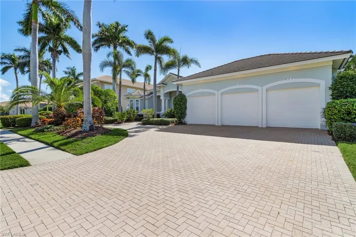 View of front 3 car garage, large pavers driveway, also featuring a circular