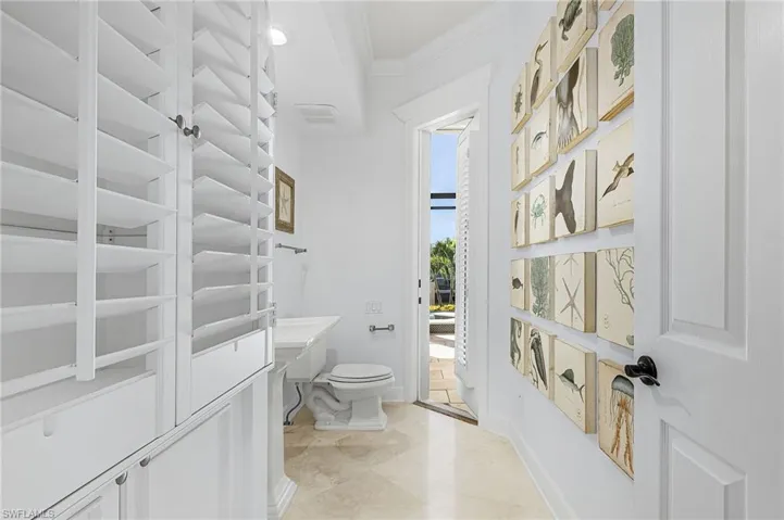 Half bath with crown molding, vanity, and marble tile  also the pool bath.