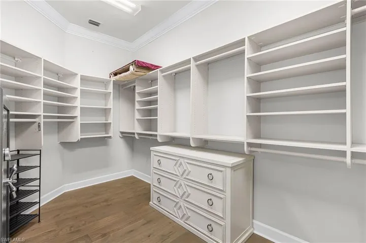 Spacious closet featuring dark wood-type flooring. Also where the safe is located.