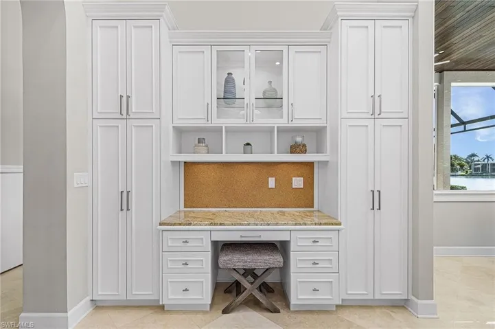 Home office featuring built in study area and light tile patterned floors