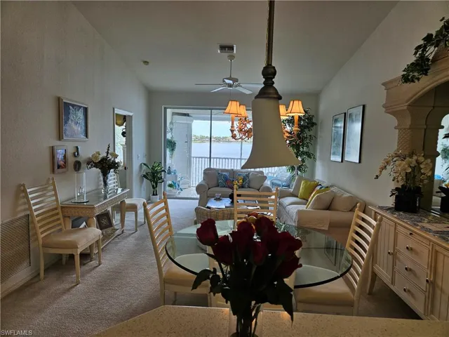 Living room featuring a water view, ceiling fan, and carpet floors