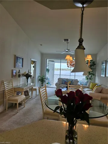 Dining space featuring a water view, ceiling fan, and vaulted ceiling