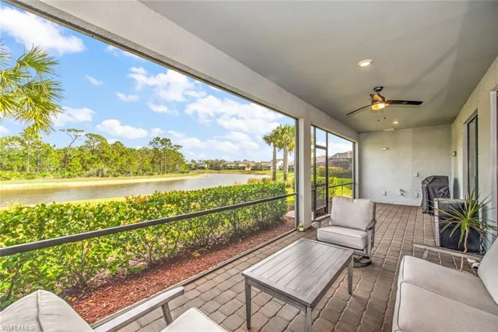 Sunroom / solarium with ceiling fan and a water view