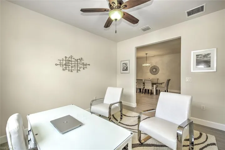 Home office with hardwood / wood-style flooring and ceiling fan