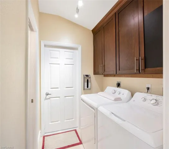 Laundry room with cabinets, hookup for an electric dryer, and washing machine and dryer