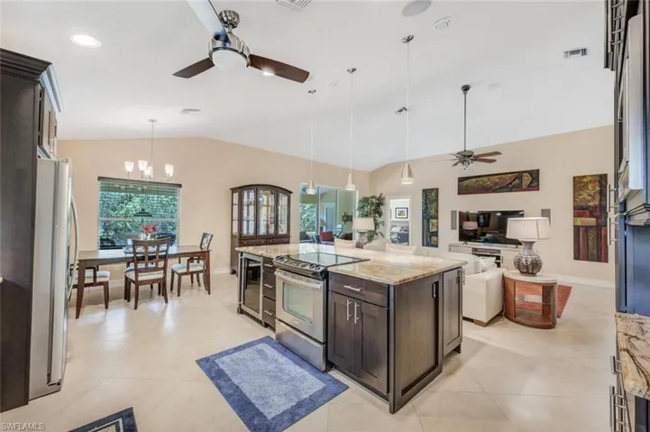 Kitchen with ceiling fan with notable chandelier, light tile floors, and appliances with stainless steel finishes