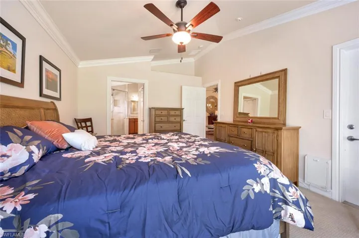 Bedroom with crown molding, ensuite bathroom, carpet floors, and ceiling fan