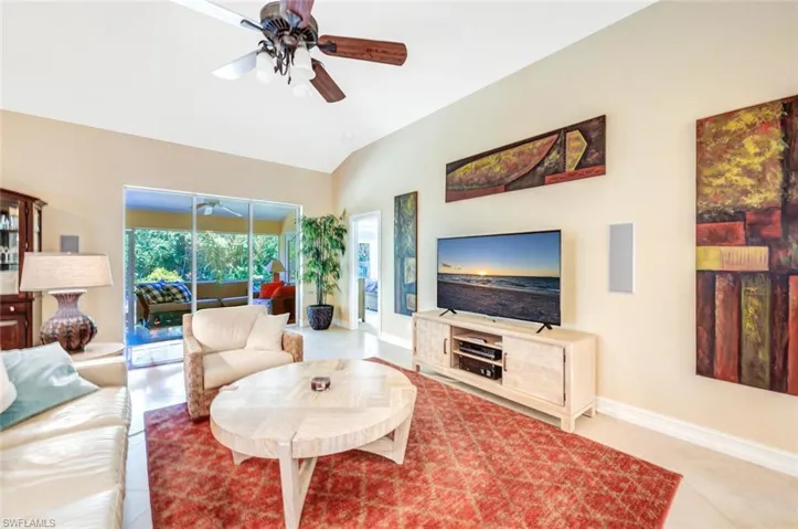 Living room featuring ceiling fan and lofted ceiling