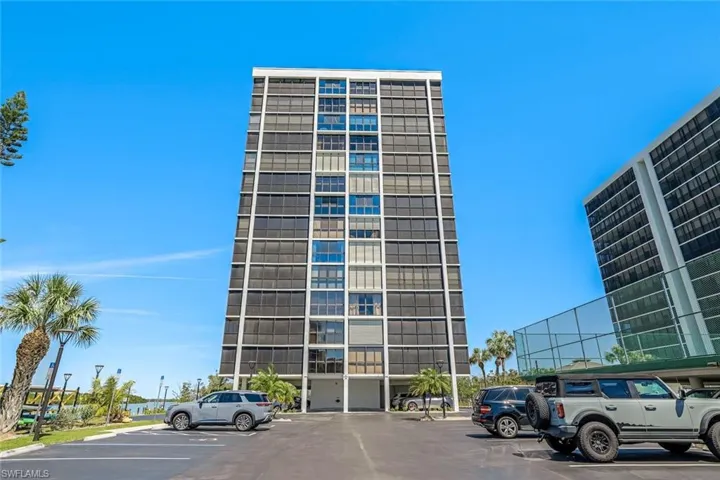 View of building exterior with uncovered parking