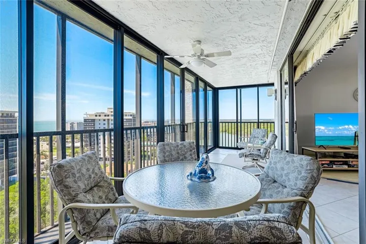 Sunroom with floor to ceiling windows, a ceiling fan, healthy amount of natural light, and a textured ceiling