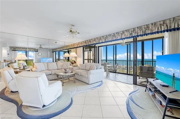 Living area with a ceiling fan and light tile patterned flooring