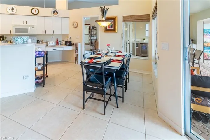 Dining space with light tile patterned floors and wine cooler