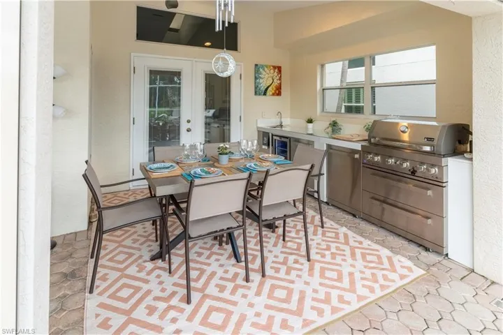 Dining room with french doors, a textured wall, and wine cooler