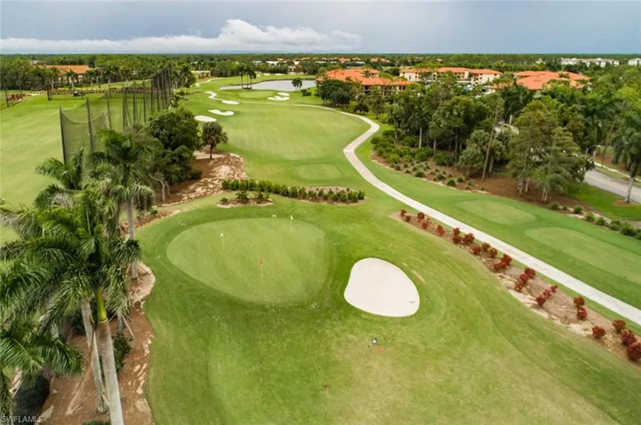 Aerial view of property and surrounding area with a golf club
