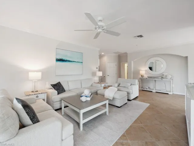 Living room featuring ornamental molding, visible vents, ceiling fan, and light tile patterned floors