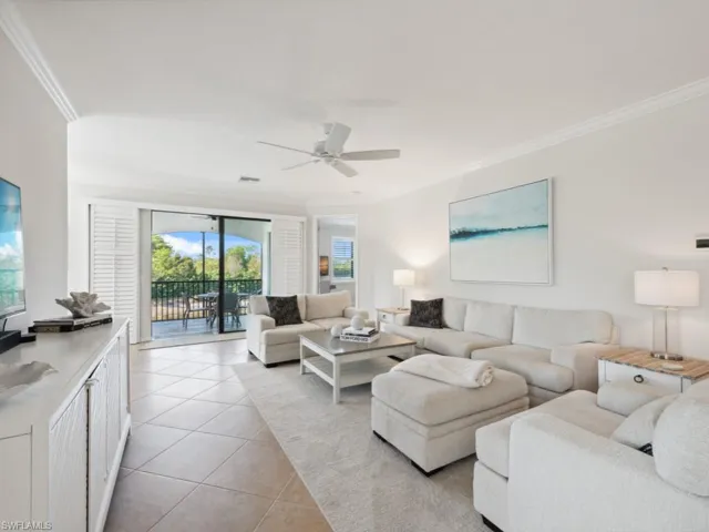 Living room with crown molding, light tile patterned floors, a ceiling fan, and visible vents