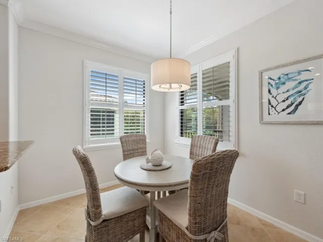 Dining room with light tile patterned floors, baseboards, and ornamental molding