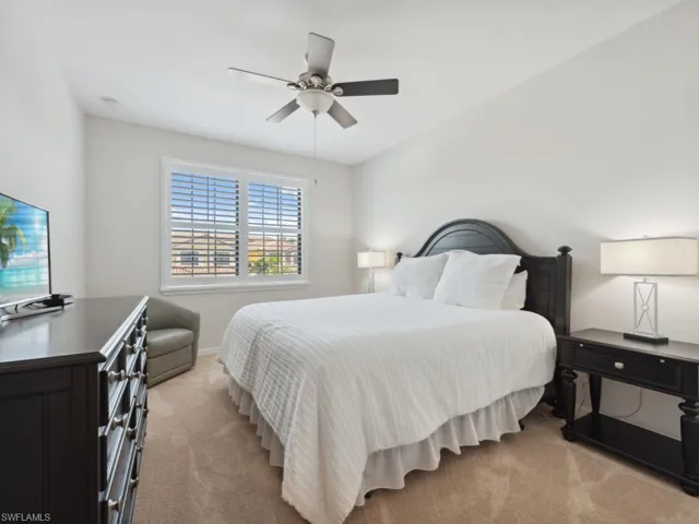 Bedroom with ceiling fan and light carpet