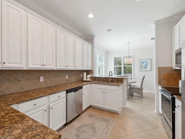 Kitchen featuring crown molding, a sink, white cabinetry, and stainless steel appliances
