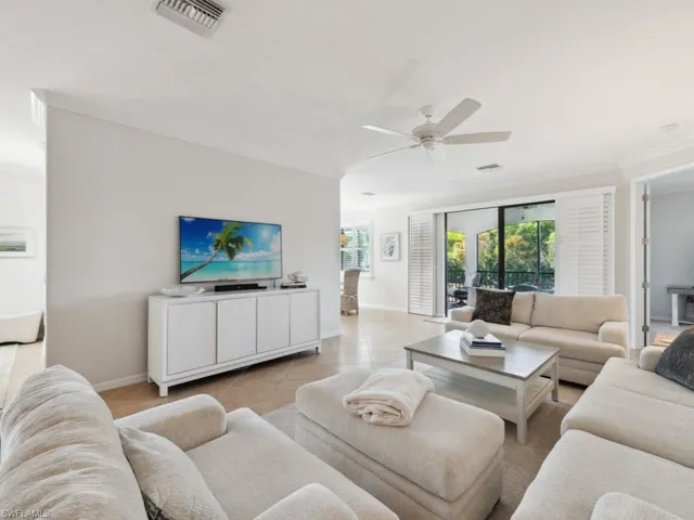 Living area featuring ornamental molding, visible vents, a ceiling fan, and light tile patterned floors